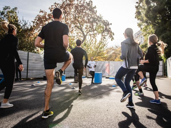 Photo d'un groupe de personne faisant un exercice de course sur place à l'extérieur