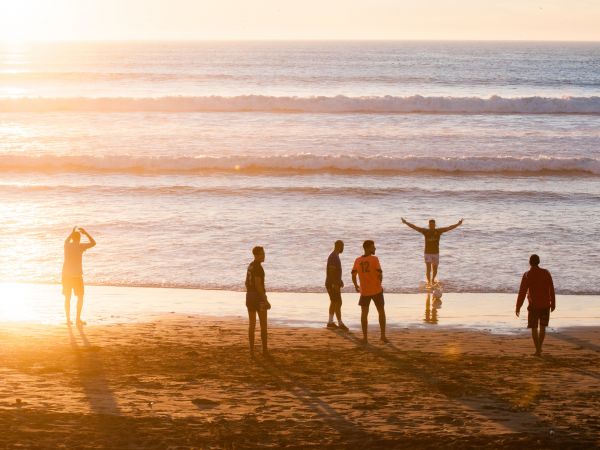 Un groupe d'amis s'amusent sur une plage au pied des vagues