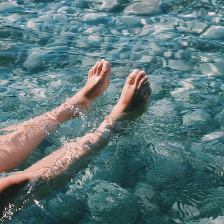 Deux jambes immergées dans une eau fraîche de rivière